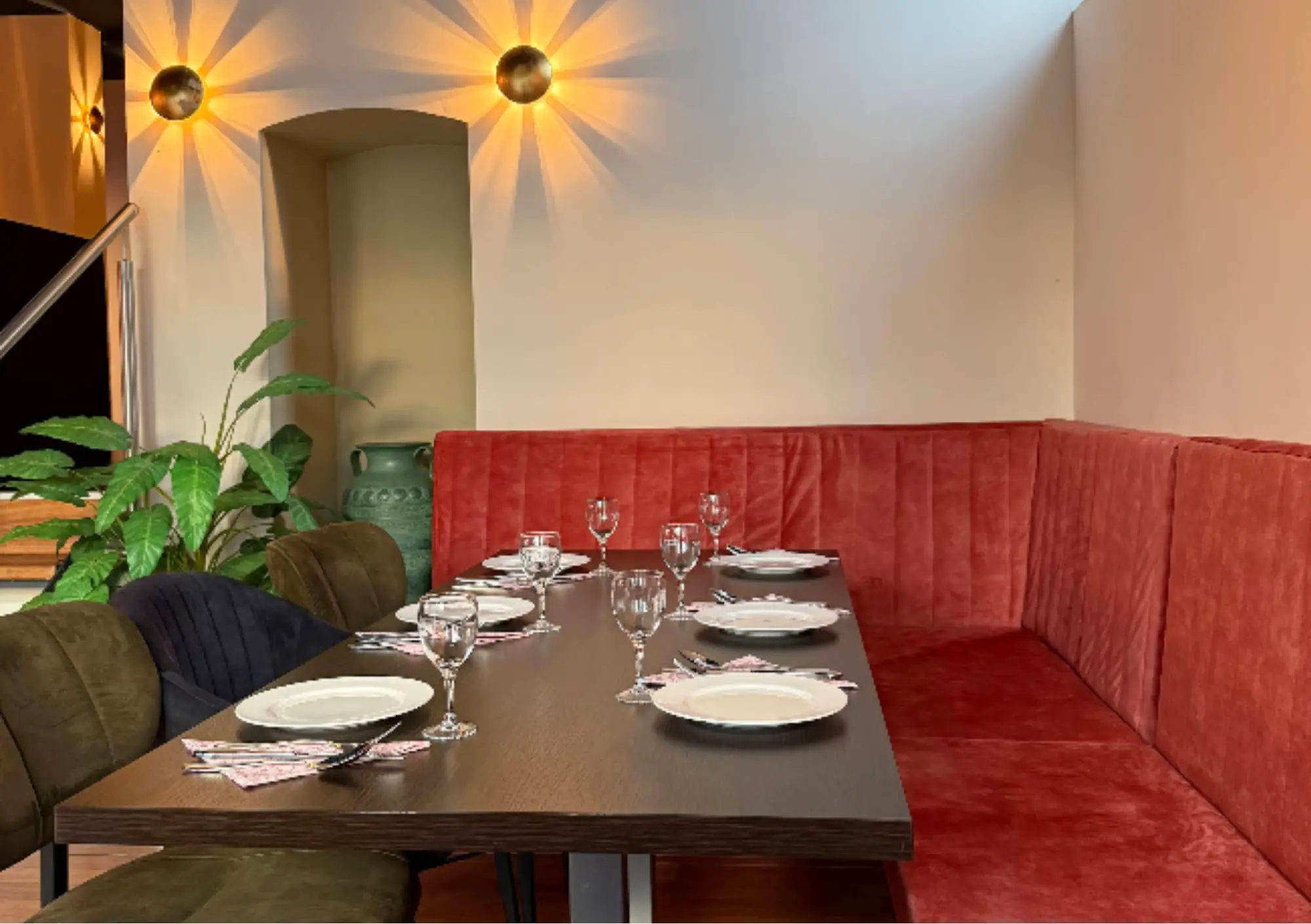 Gemütliche Sitzecke mit rotem Samtsofa und gedecktem Tisch im Blue Feathers Kaiserslautern